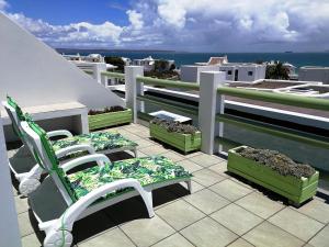un balcón con 2 sillas y plantas en el techo en Langebaan Paradise Beach Self Catering 5 Elara en Langebaan