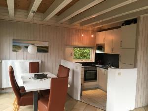 a kitchen and dining room with a table and chairs at Ferienhauser Lensterstrand in Lenste