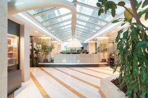a conservatory with a glass ceiling and a lobby at Mercure Roma West in Mostacciano