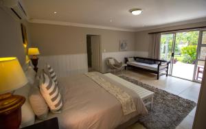 a bedroom with a large bed and a living room at House on Olof Palme in Windhoek