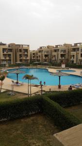 a large swimming pool with umbrellas in a city at Chalet Accacia 39 in Blue Bay Asia in Ain Sokhna