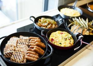 a bunch of different types of food on a stove at Hotel Intergate Hiroshima in Hiroshima