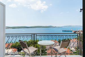 ein Balkon mit Tisch und Stühlen und Blick auf das Wasser in der Unterkunft Villa Boris in Trogir