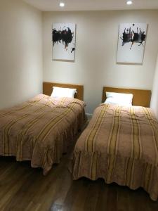 dwa łóżka siedzące obok siebie w pokoju w obiekcie Hakuba West Coast Inn, Villa w mieście Hakuba