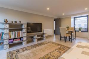 sala de estar con TV de pantalla plana y mesa en Chambre d'hôtes La Longère en Sotteville