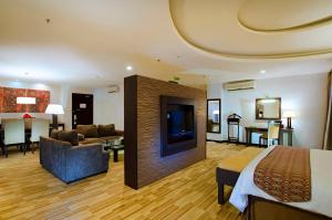 a hotel room with a bed and a living room at ASTON Pontianak Hotel and Convention Center in Pontianak