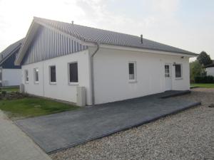 a white house with a driveway in front of it at Altefähr Haus 42 in Altefähr