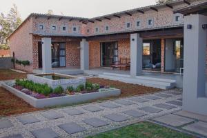 a brick building with a garden in front of it at Figberry Guestrooms in Bloemfontein