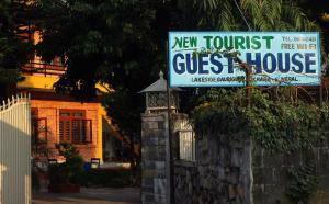 un nuovo cartello turistico per la pensione di fronte a una casa di New Tourist Guest House a Pokhara