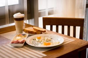 a plate of eggs and toast and a drink on a table at Apart39 in the City Centre in Kaliningrad