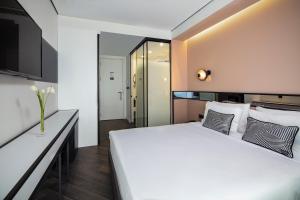 een slaapkamer met een groot wit bed en een televisie bij The Westist Hotel & Spa - Special Category in Istanbul