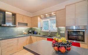 a kitchen with a bowl of fruit on a table at Villa VerMera in Zakynthos