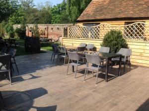 a patio with tables and chairs and a fence at Plum Pudding in Abingdon