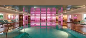 einen Pool in einem Gebäude mit rosa Wänden in der Unterkunft GRAND ELYSEE Hamburg in Hamburg