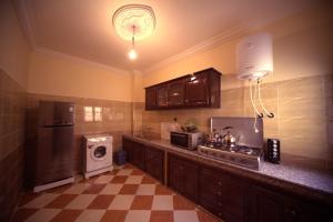 a kitchen with a stove and a sink and a refrigerator at Résidence dikre in Ouarzazate