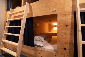 a wooden bunk bed with a bed in it at Guesthouse Akicafe Inn in Hiroshima