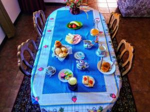 a table with a blue table cloth with food on it at Casa Vale do Rio Ovil in Baião