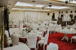 a banquet hall with white tables and white chairs at Ege Palas in İzmir +62 photos