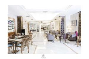 a restaurant with tables and chairs in a room at Ege Palas in İzmir