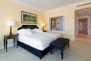 a bedroom with a large white bed and a stool at The Yeatman in Vila Nova de Gaia
