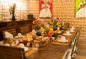 a long wooden table with food on it at Casa Angatu in Trancoso