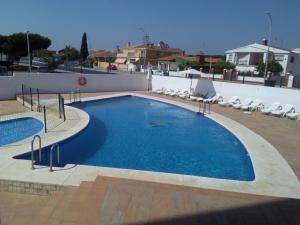 une grande piscine avec des chaises sur le toit dans l'établissement Hotel Carabela Santa María, à Mazagón