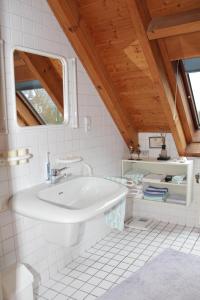 a white bathroom with a sink and a window at Ferienhaus "Alte Mühle" in Wiehl