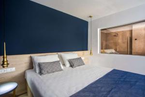 een slaapkamer met een groot bed met een blauwe muur bij Madison Boutique, Faliraki in Faliraki