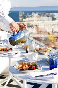 eine Person, die einen Drink mit Essen auf einen Tisch gießt in der Unterkunft Riad Dar Saba - Saba's House in Tangier