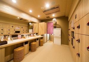 a large kitchen with a counter and a refrigerator at Dormy Inn Premium Tokyo Kodenmacho in Tokyo