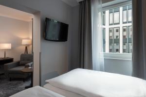 a hotel room with a bed and a window at Wyndham Köln in Cologne