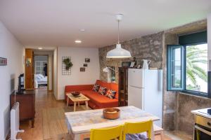cocina y sala de estar con nevera blanca en Apartamentos O Almacen, en Finisterre