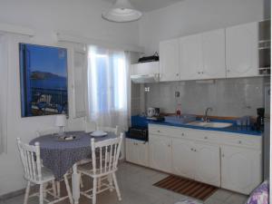 a kitchen with a table and chairs and a sink at Meltemia Studios in Marathokampos