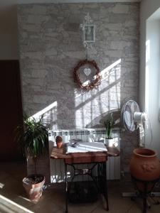 a kitchen with a table and a stone wall at Ai tre archi in Mascali