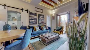 een woonkamer met een blauwe bank en een tafel bij Bright and new- 2Bd 2Bth- Conde de Torrejon in Sevilla