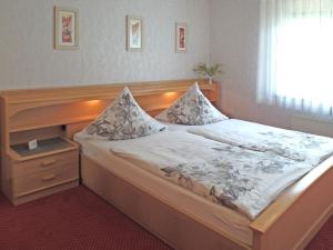 een slaapkamer met een groot bed met een houten hoofdeinde bij Ferienwohnung in der Nähe des Skigebietes in Willingen