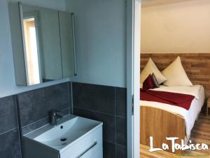 uma casa de banho com um lavatório e uma cama com um espelho. em Hotel Schurwald em Rechberghausen