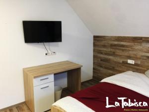 1 dormitorio con 1 cama y escritorio con TV en la pared en Hotel Schurwald en Rechberghausen