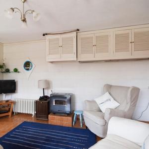 a living room with a couch and a tv at Seaside Cottage in Wexford