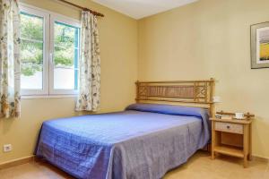 1 dormitorio con cama y ventana en Villa Alicia, en Cala Galdana