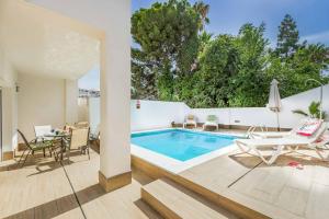 a house with a swimming pool and a table and chairs at Villa Valeria in Nerja