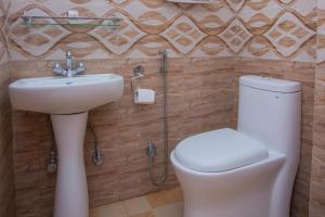 een badkamer met een wit toilet en een wastafel bij Hotel Romantica in Pokhara +19 foto's