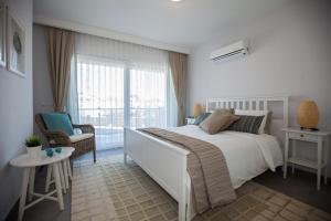 een witte slaapkamer met een bed en een raam bij Truemar Hotels & Suites in Kemer