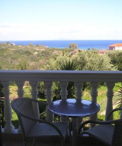 a table and chairs on a balcony overlooking the ocean at Nikolaos Studios Skala in Skala