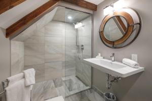 uma casa de banho com um chuveiro, um lavatório e um espelho. em The Victorian Luxury Suites em Westport