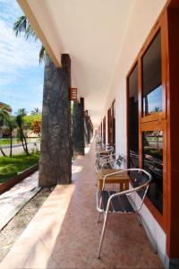 a row of tables and chairs next to a building at RedDoorz Plus At Hotel Sofia Pangandaran in Pangandaran