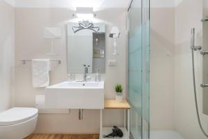 biała łazienka z umywalką i prysznicem w obiekcie Mirtì boutique Apartment heart Cagliari w Cagliari +20 zdjęć