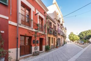 ulica na Starym Mieście z czerwonymi budynkami w obiekcie Mirtì boutique Apartment heart Cagliari w Cagliari