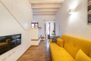 salon z żółtą kanapą i kominkiem w obiekcie Mirtì boutique Apartment heart Cagliari w Cagliari