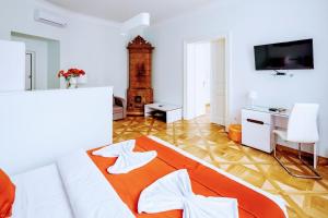リヴィウにあるFamily apartments in Lviv center with balconyの白いベッドルーム(オレンジと白のベッド付)